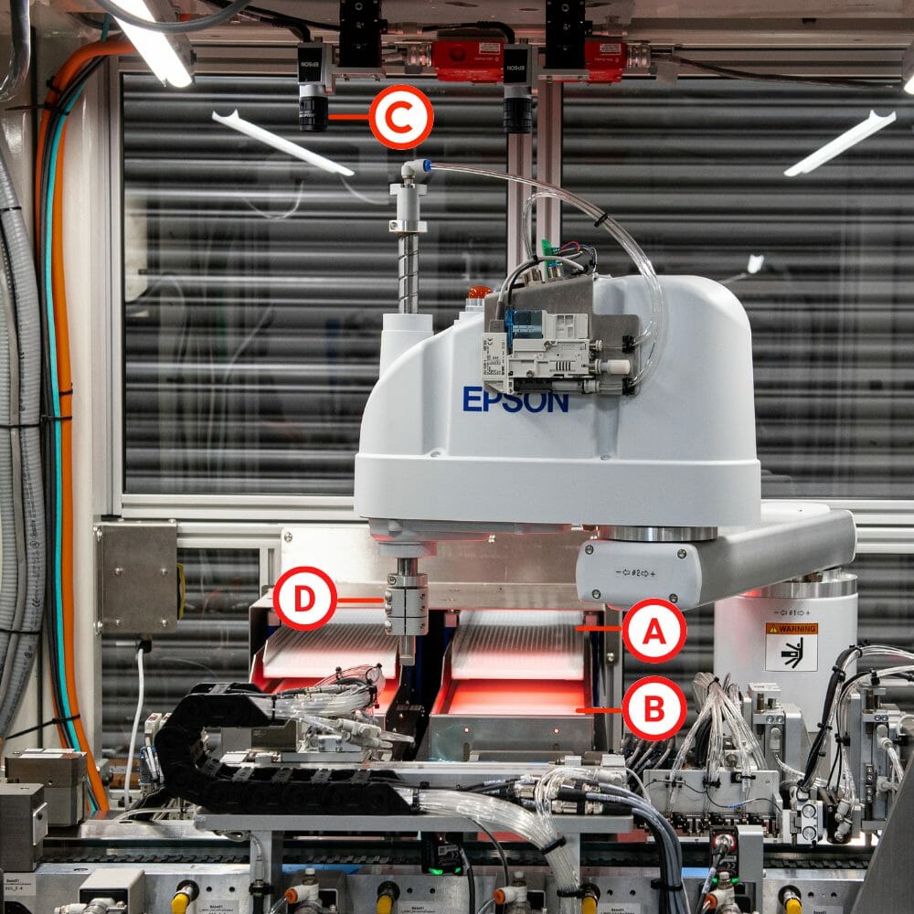 Two flex feeders with a vision system above and a robotic arm to move parts from the feed deck