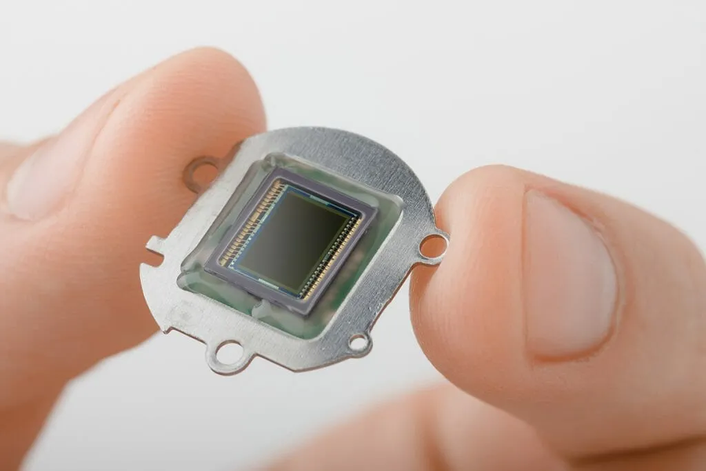 Small digital camera sensor plate in fingers