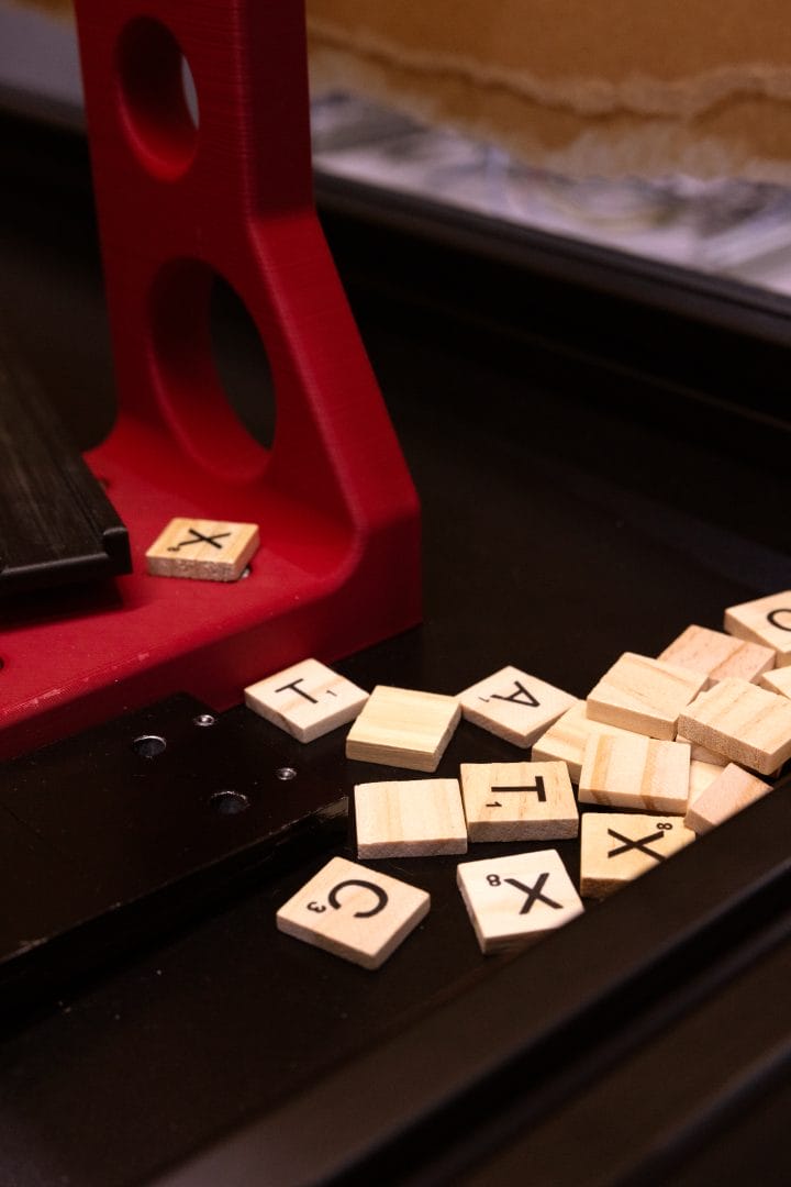 FANUC Robot Demo | AC's Booth at ATX West 2024 | Image showing a scattered group of gameboard letter tiles the robot would use to spell out a phrase during the trade show demonstration