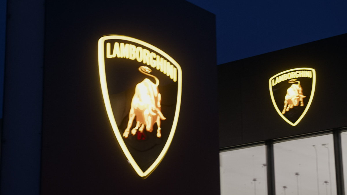 Illuminated Lamborghini emblems on a building at night