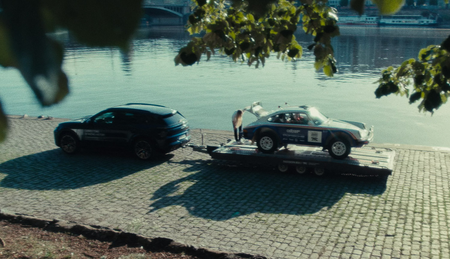 Two Porsche cars beside the water