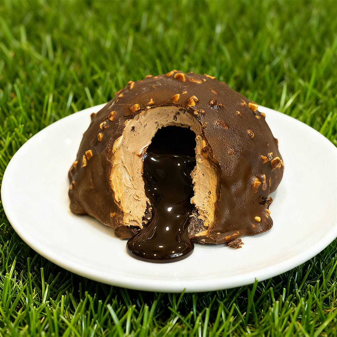 Dolce al cioccolato con nocciole, ripieno di crema al cioccolato fondente che si riversa su un piatto bianco.