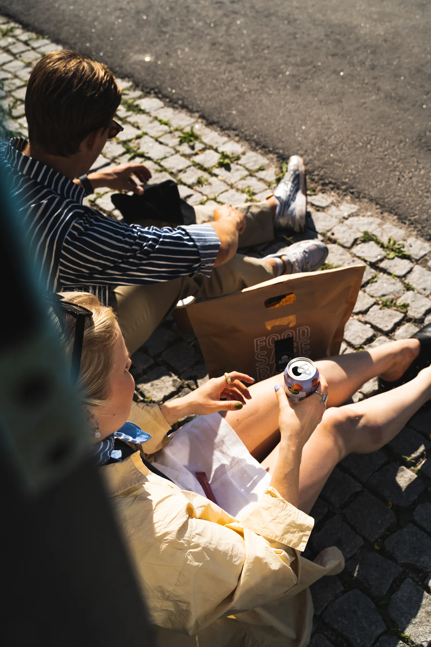 Henkilö pitelee tarjotinta, jolla on juustohampurilainen, uritetut ranskalaiset metallikorissa, tölkki Pepsi Maxia, milkshake kermavaahdolla ja pieni kuppi kastiketta.