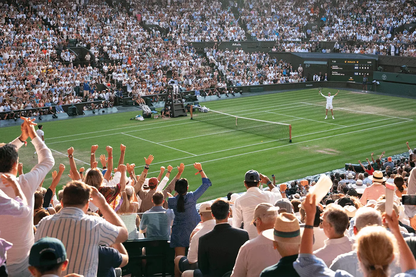Panoramic view of a brightly lit soccer stadium with spectators watching a match on the green field at night.