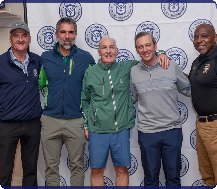 Five men standing in front of an Atlanta Police Foundation backdrop, smiling with arms around each other.