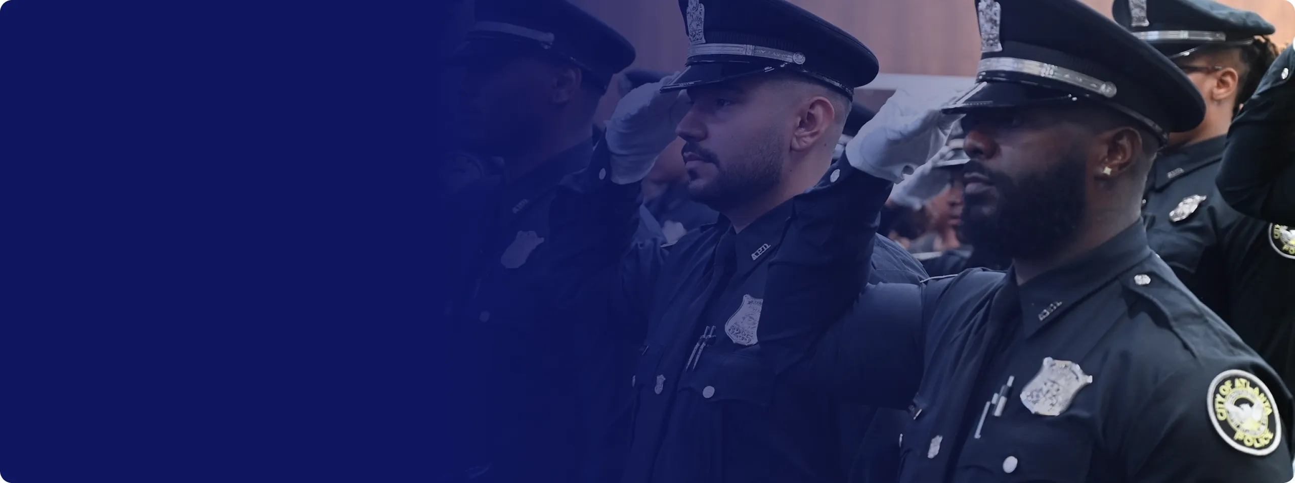 Police officers in uniform saluting during a ceremony.