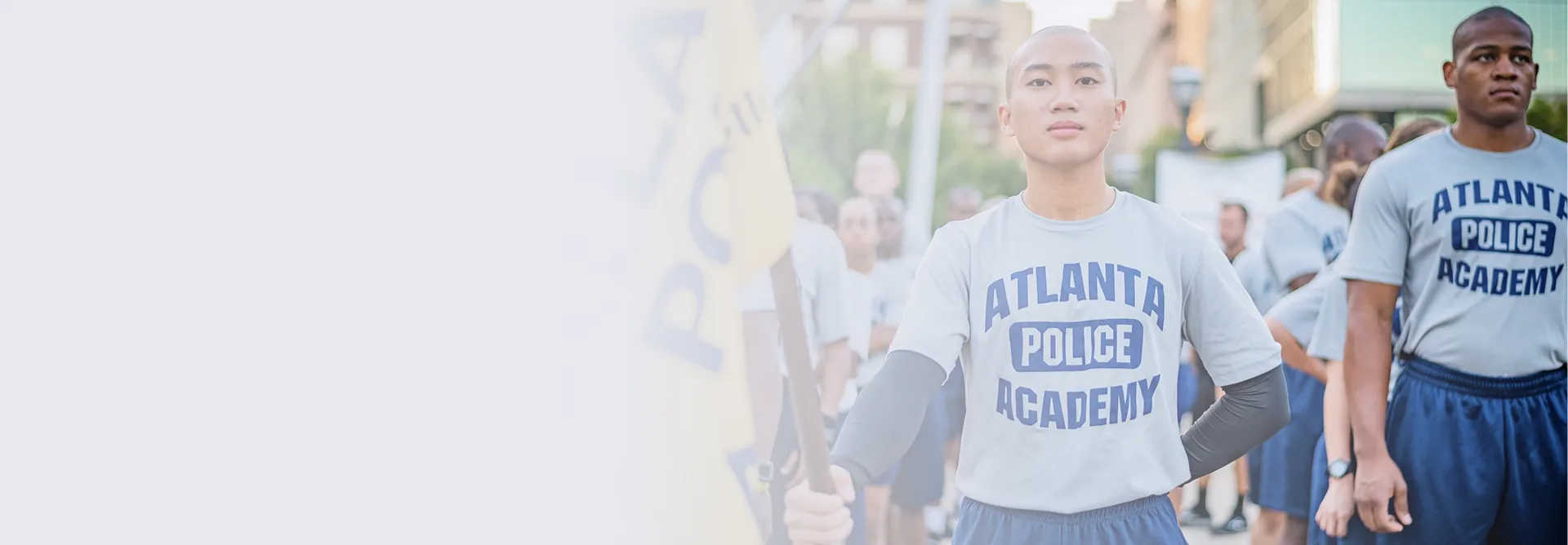 Young recruits in Atlanta Police Academy uniforms standing in formation outdoors during training.