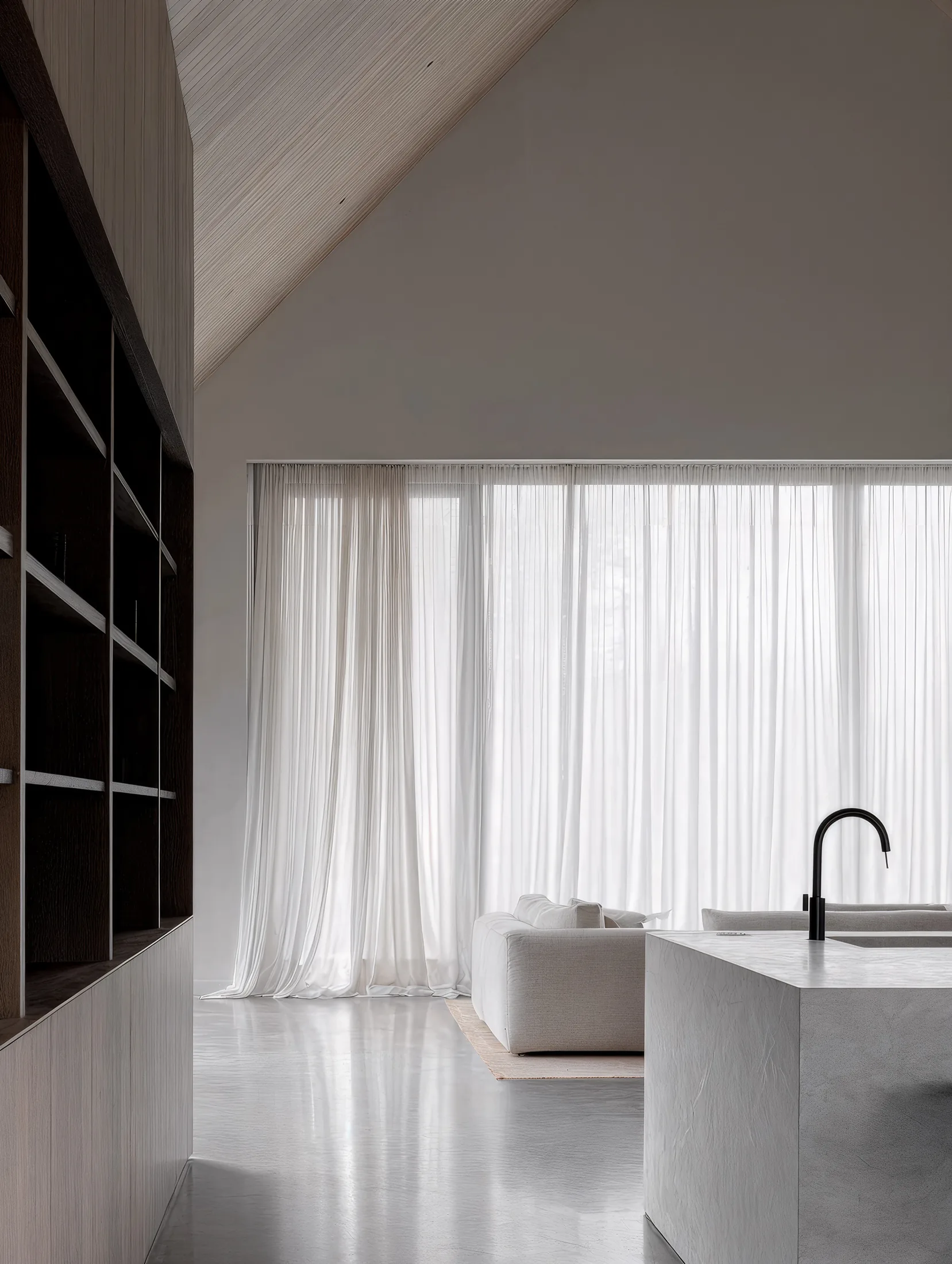 Living room of the Saint Prix family house opening onto the garden through large glazing