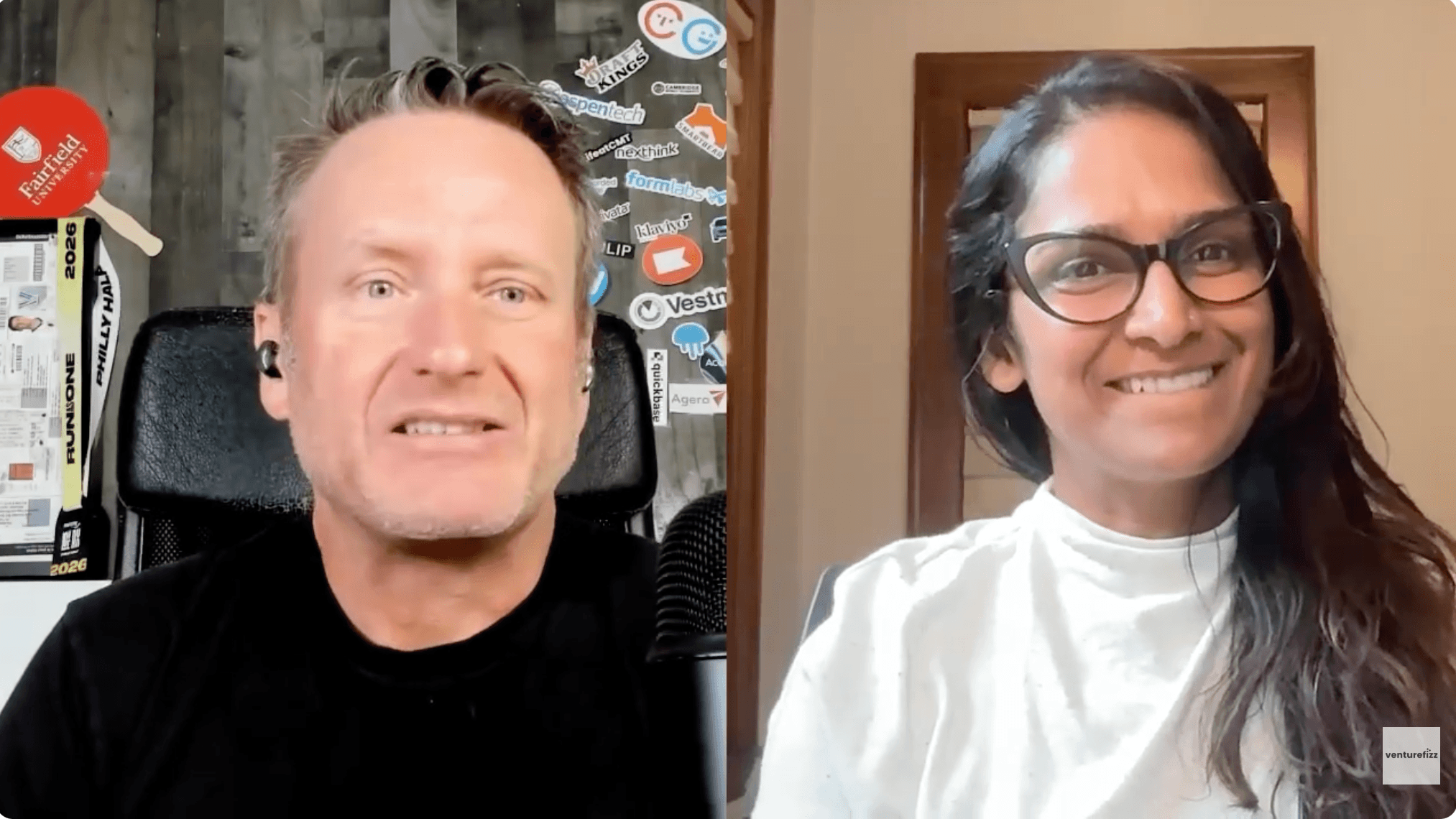 A split-screen view of a virtual video call featuring a man on the left speaking against a backdrop with logos and a ping pong paddle, and a smiling woman on the right wearing black cat-eye glasses and a white top.