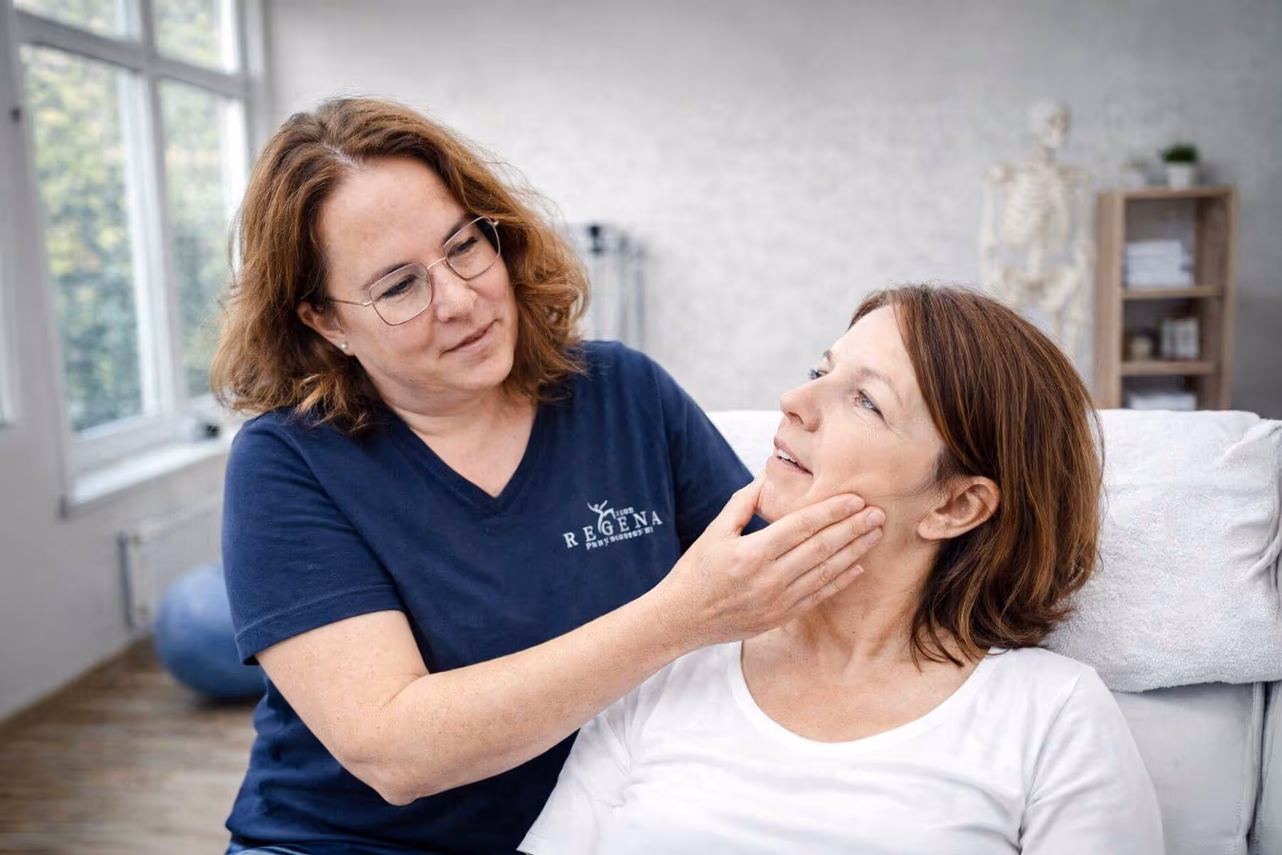 Physiotherapeutin behandelt Kiefergelenk bei CMD-Therapie in moderner Praxis