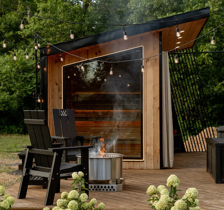 3D render of a Modern A-frame cabin with large triangular window showing a bed inside, set on green grass with a covered porch and swing.