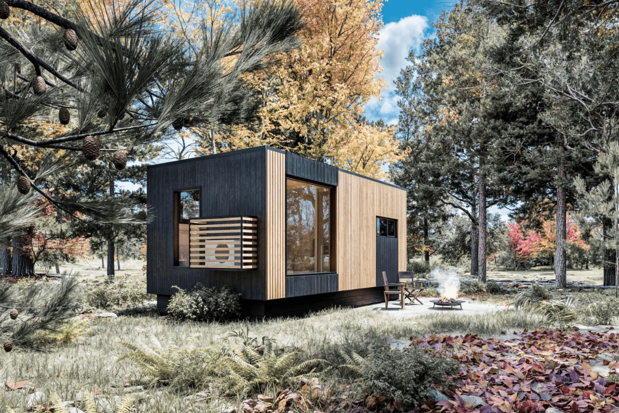 A modern tiny house with wood and dark paneling sits in a forest clearing surrounded by trees, with two chairs by a small fire pit in the foreground.