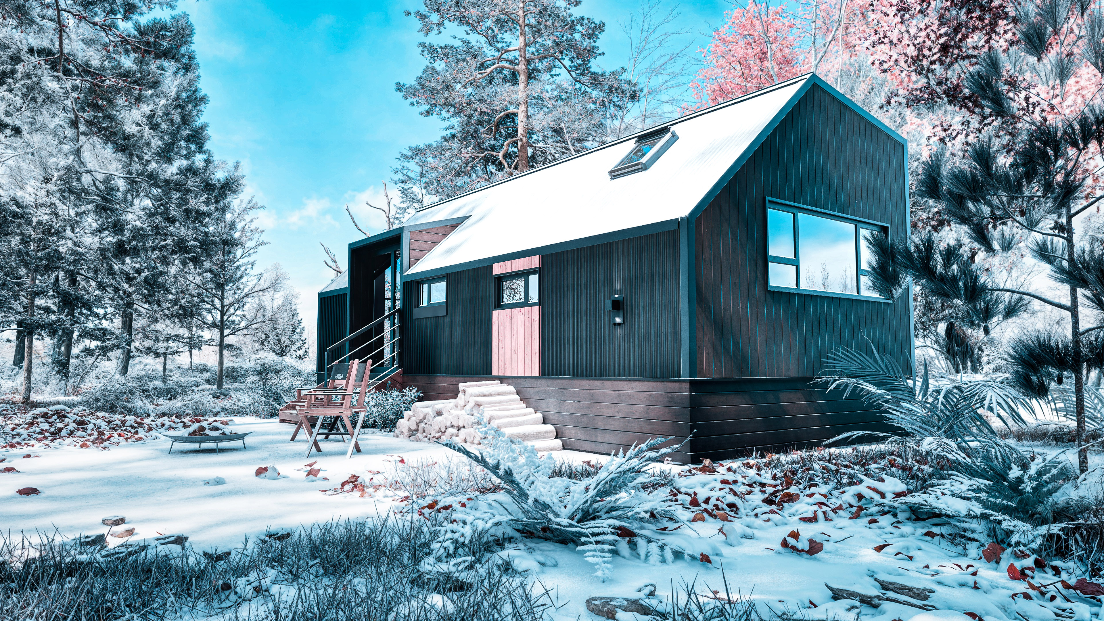 A modern tiny house with large windows sits on snowy ground surrounded by trees, with a fire pit and chairs in the foreground.