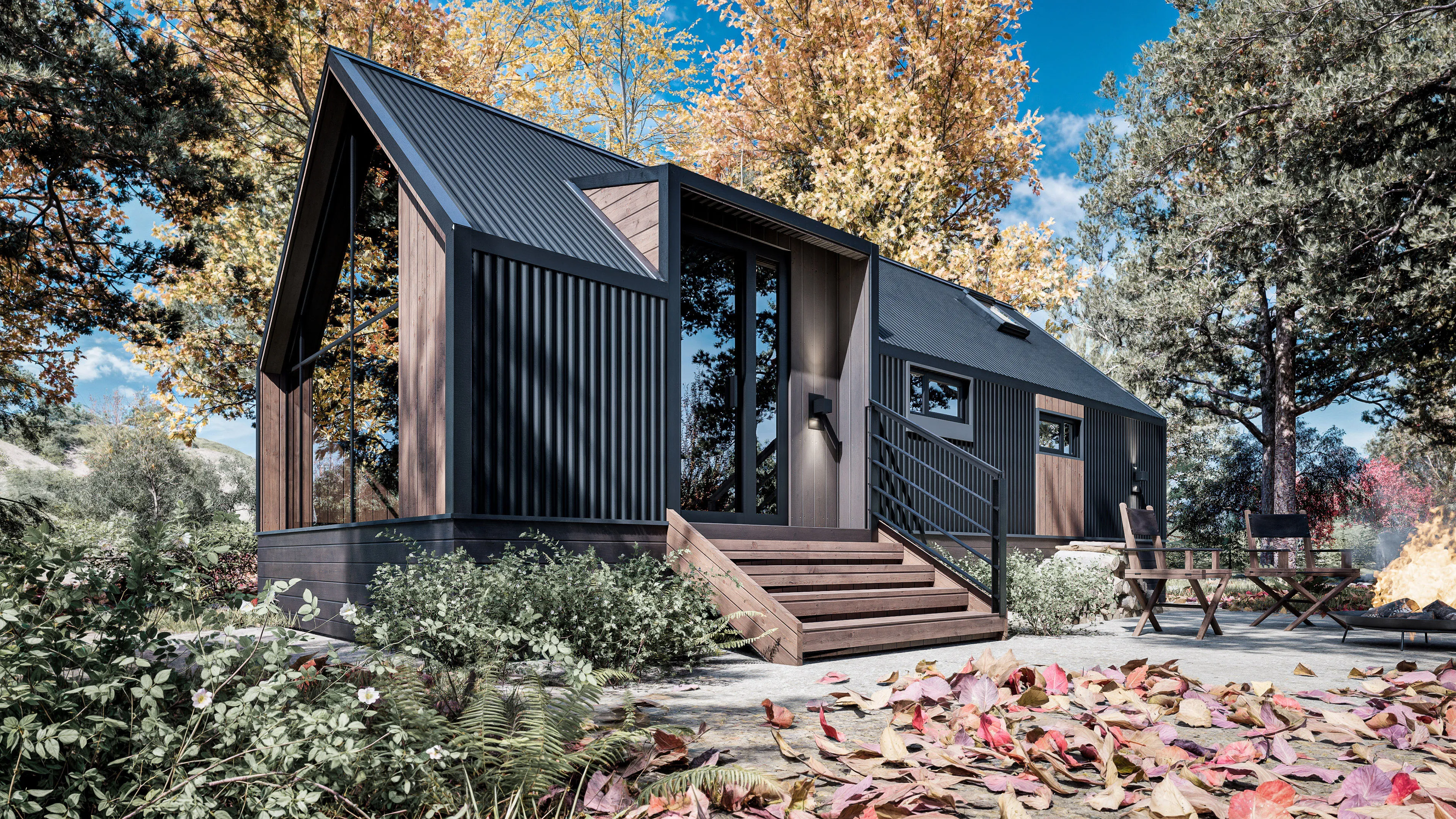 Modern black tiny house with wood accents, situated among trees with fallen leaves, features a small porch, outdoor seating, and a fire pit under a bright sky.