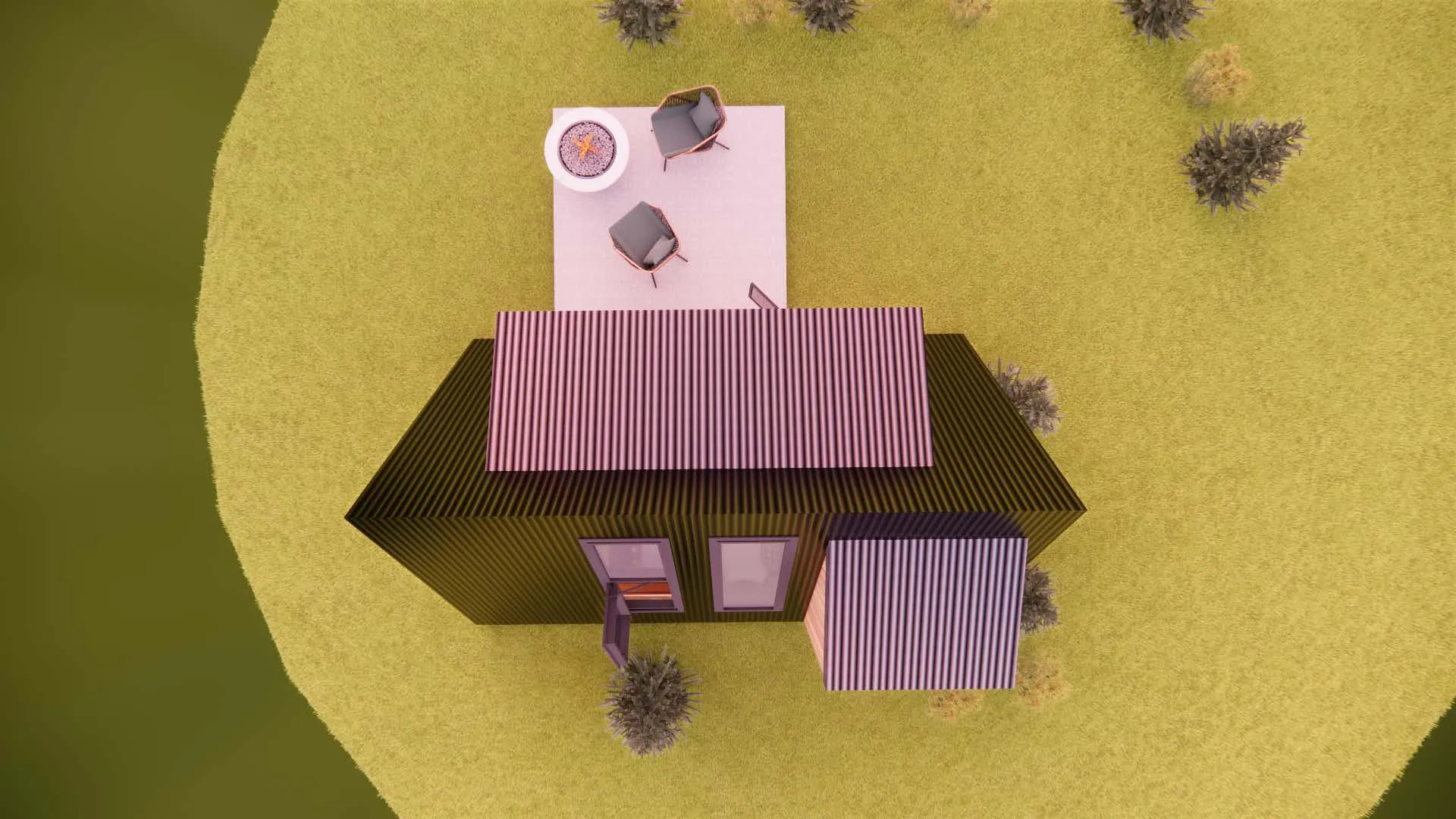 Aerial view of a small modern house with a deck, two chairs, and a fire pit, surrounded by grass and scattered bushes.