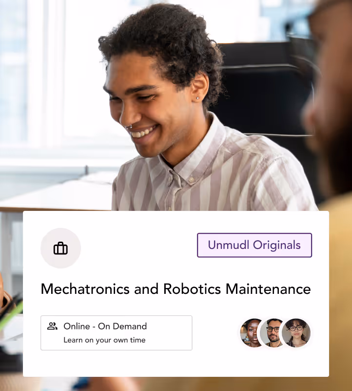 Smiling man with curly hair in a striped shirt participating in an online mechatronics and robotics maintenance course.
