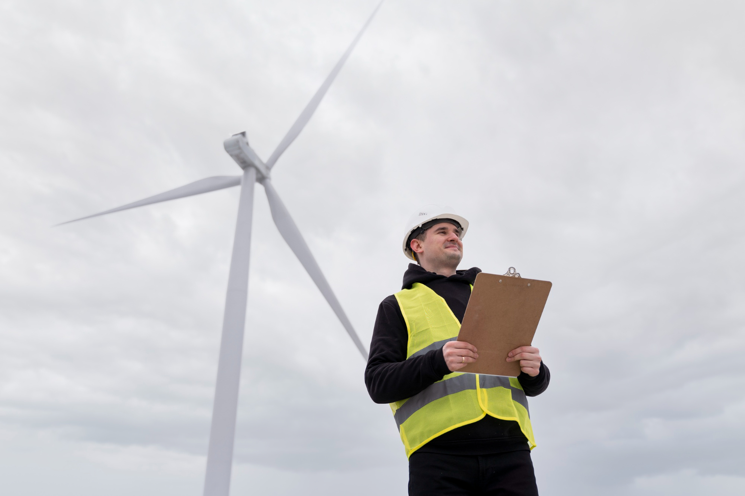Wind turbine technician in a lift bucket inspecting turbine blades