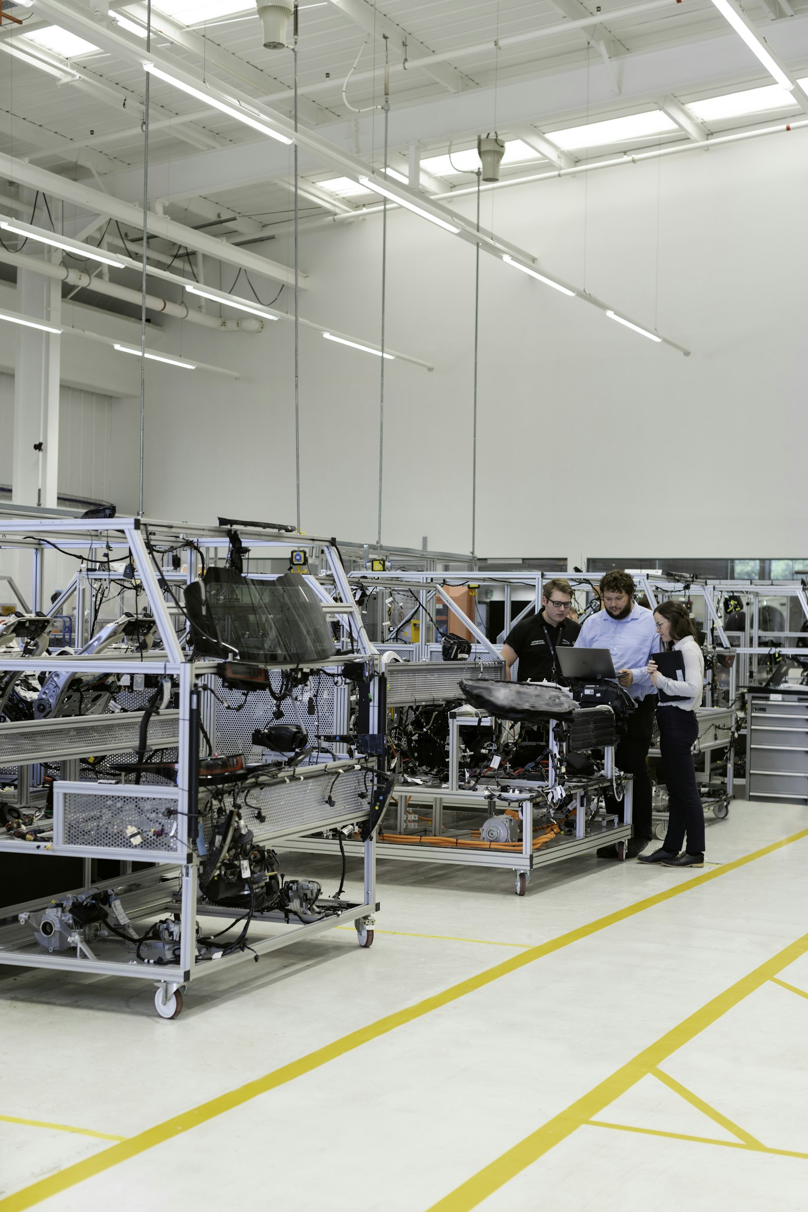 Team of technicians working together on industrial equipment in a modern facility