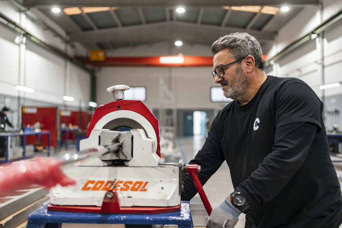 A technician operates industrial machinery in a workshop