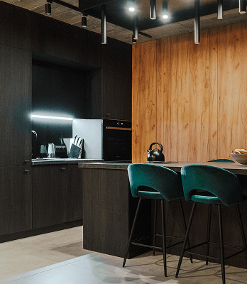 Kuchnia ze stołem, krzesłami i czajnikiem na blacie.