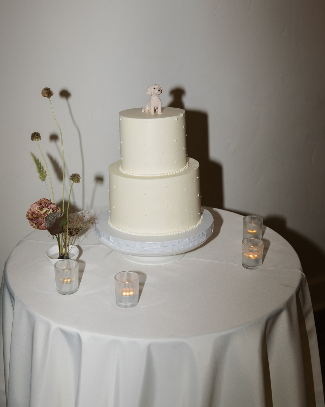 Modern wedding cake with dog cake topper.