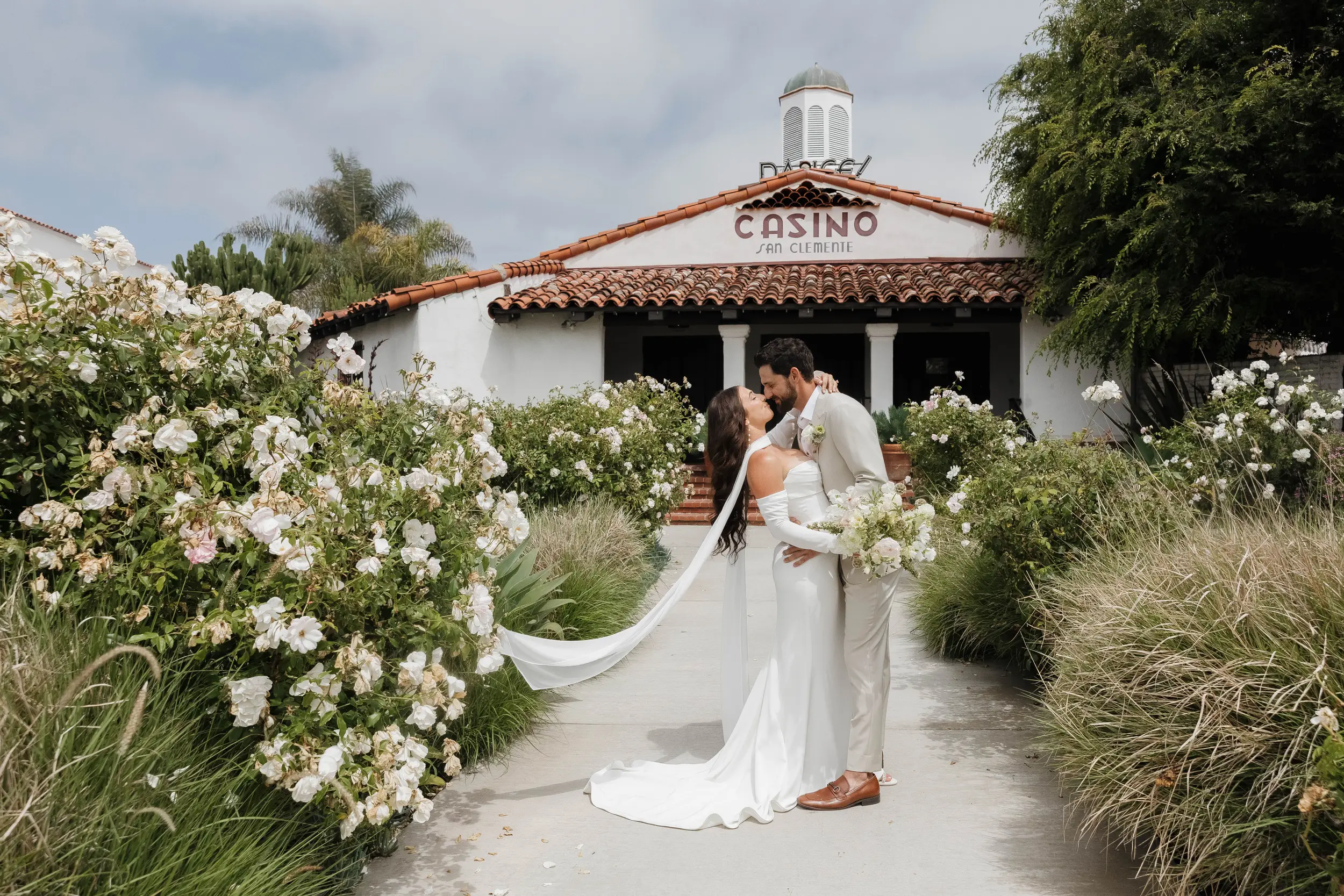 Bride and groom share a kiss outside of the Casino San Clemente.