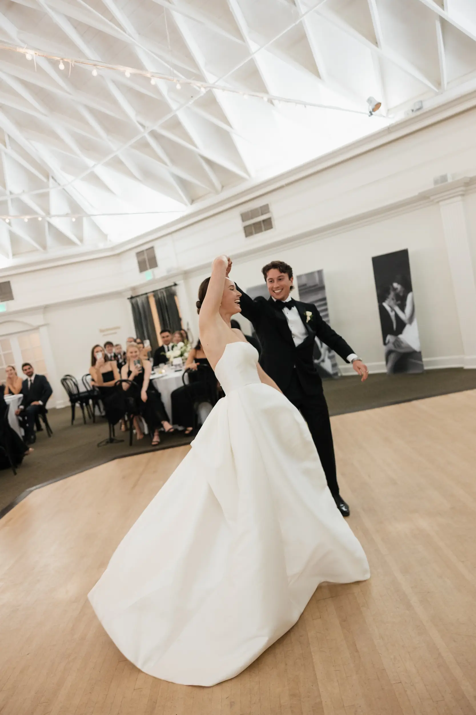 Groom twirls bride on the dance floor for their first dance.