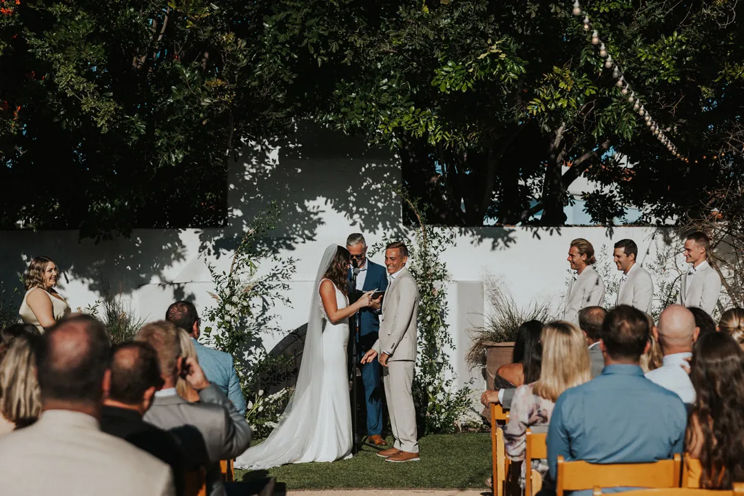Groom smiles as bride shares her vows.