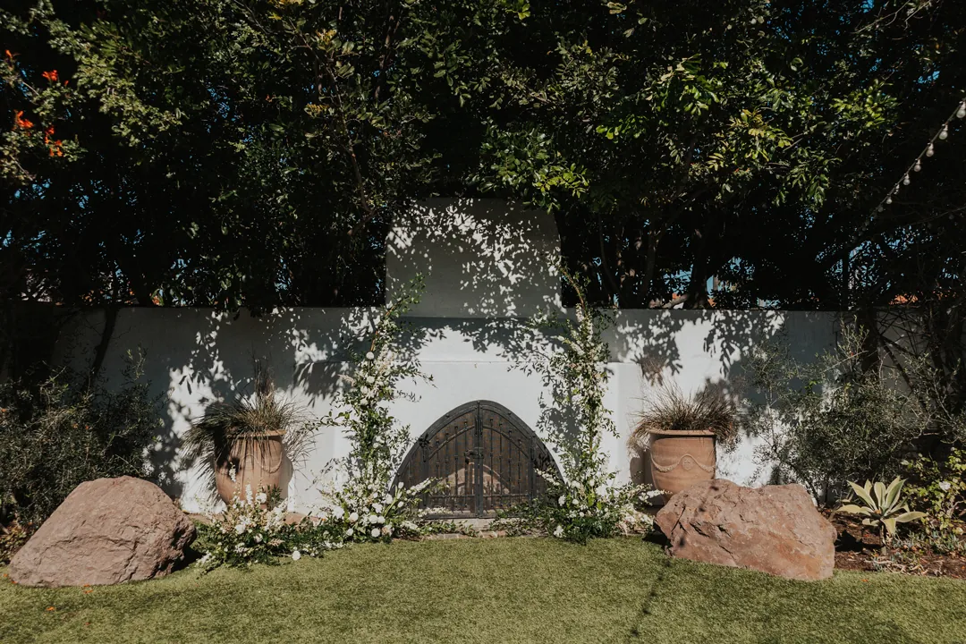 White florals and greenery frame in the Casino's outdoor fireplace.