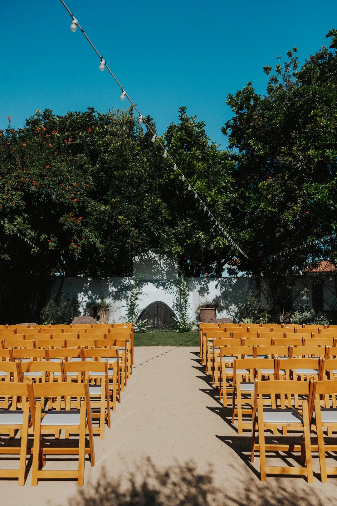 Ceremony is set with white florals and greenery.