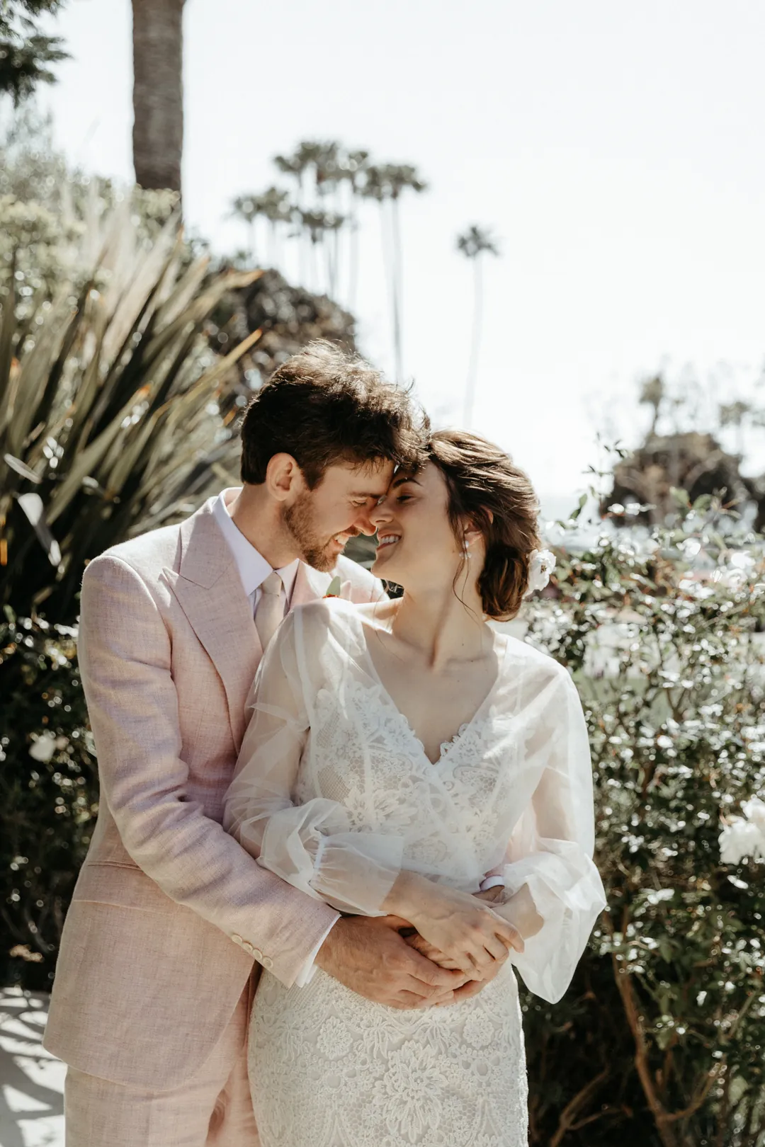 Bride and groom smile at each other for a photo.