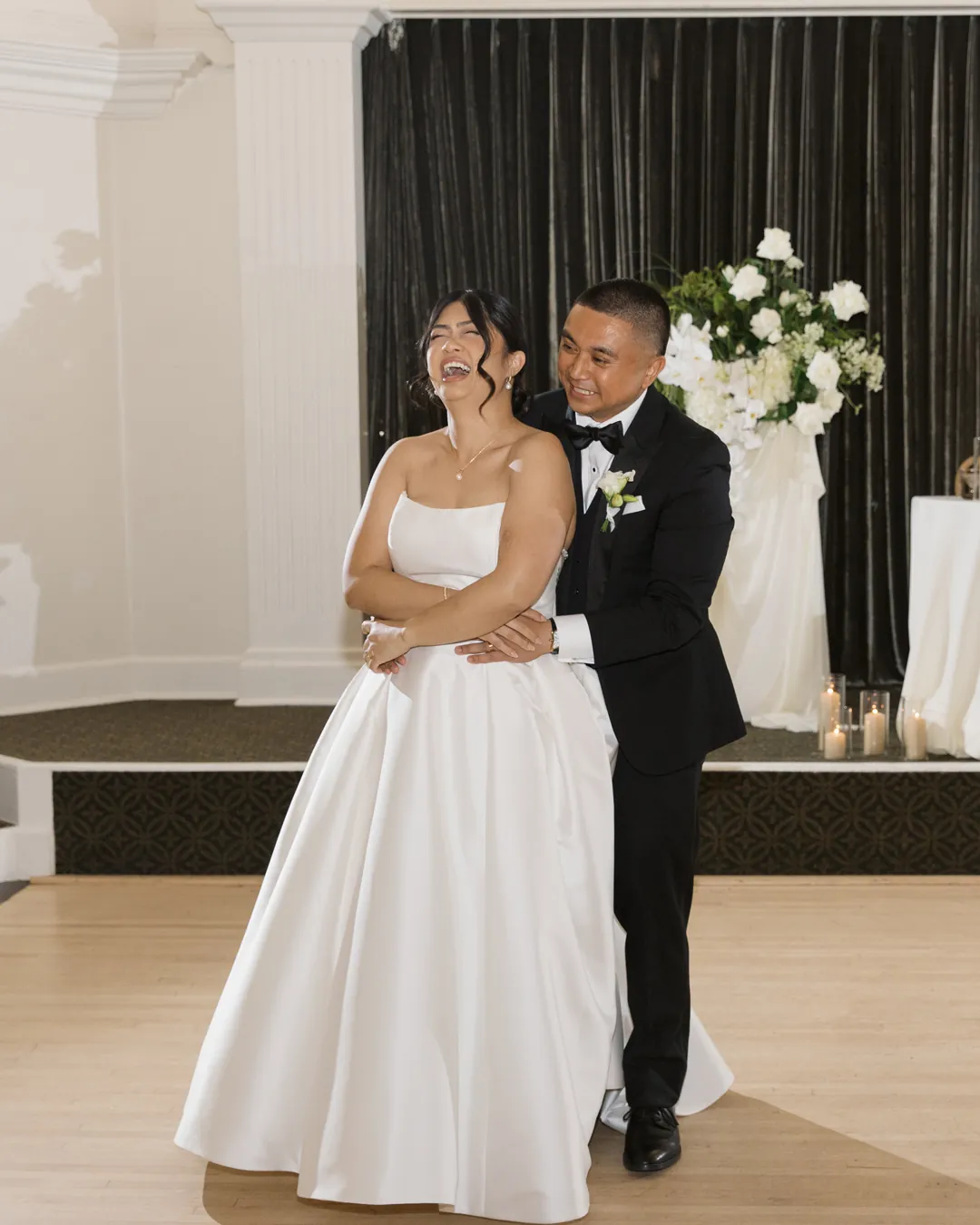 Bride and groom smile as they share their first dance.