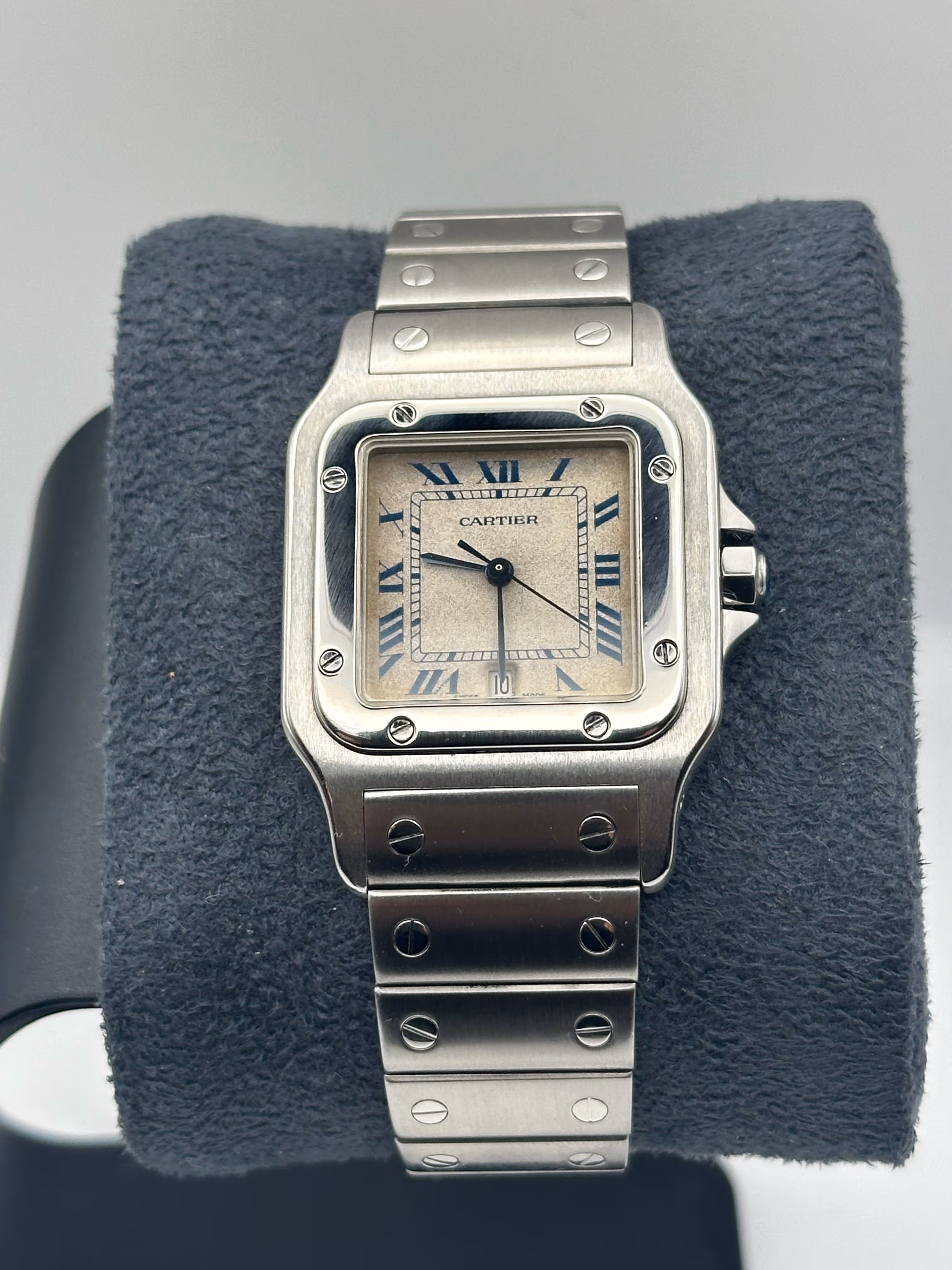 Cartier Santos Galbée référence 987901 en acier, boîtier 29 mm aux lignes emblématiques de la maison Cartier, animée par un mouvement quartz alliant fiabilité et confort d’usage quotidien. Cette pièce se distingue par son cadran patiné au charme authentique, sublimé par de superbes aiguilles bleuies apportant contraste et élégance. La montre a été révisée en avril 2026 et présente un boîtier poli, offrant une très belle présence au poignet. Elle est accompagnée de sa boîte ainsi que de ses papiers vierges, un ensemble recherché pour cette référence devenue incontournable de la collection Santos.