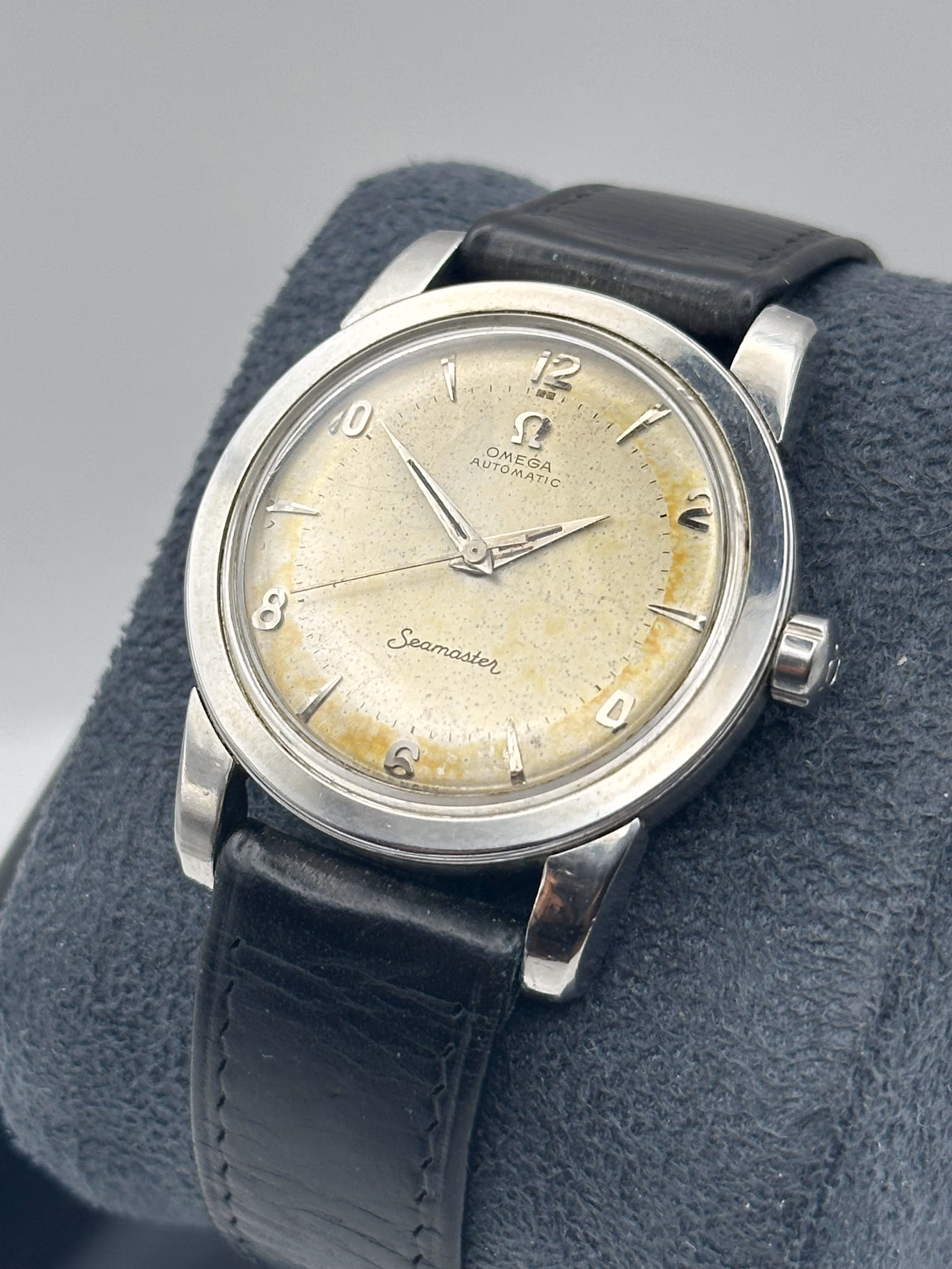 Omega Seamaster automatique vintage à remontage « bumper » – 1947 – Réf. 2757-1 SC – Calibre 351. Véritable classique de la première époque des montres automatiques Omega, cette Seamaster de 1947 est équipée du robuste calibre 351 à remontage « bumper », récemment révisé et doté d’un nouveau ressort de barillet afin de garantir un fonctionnement fiable. Son boîtier en acier inoxydable (réf. 2757-1 SC) mesure 34,5 mm et arbore les célèbres cornes épaisses (« beefy lugs »), une caractéristique emblématique des premières Seamaster particulièrement appréciée des collectionneurs. Le cadran a vieilli avec élégance et présente une belle patine vintage chaleureuse. Il est associé à de raffinées aiguilles dauphine et à des index appliqués. Le boîtier demeure dans un excellent état compte tenu de son âge, conservant les lignes affirmées et les proportions harmonieuses qui ont marqué le design Omega de l’après-guerre. Une montre aussi belle que saine sur le plan mécanique, idéale pour les amateurs d’horlogerie souhaitant profiter de l’héritage et du charme unique des premiers mouvements automatiques à remontage « bumper ».