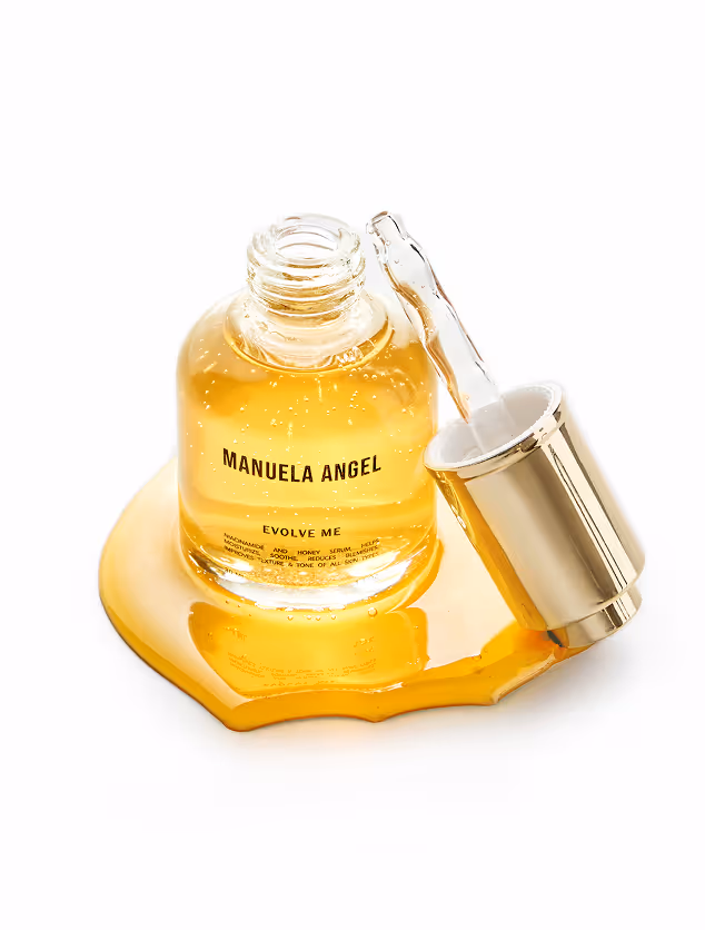 High-end e-commerce product photography by Gooper featuring a golden beauty serum bottle with a glass dropper, glossy oil spill, clean white negative space, and a refined studio composition for premium skincare brands.