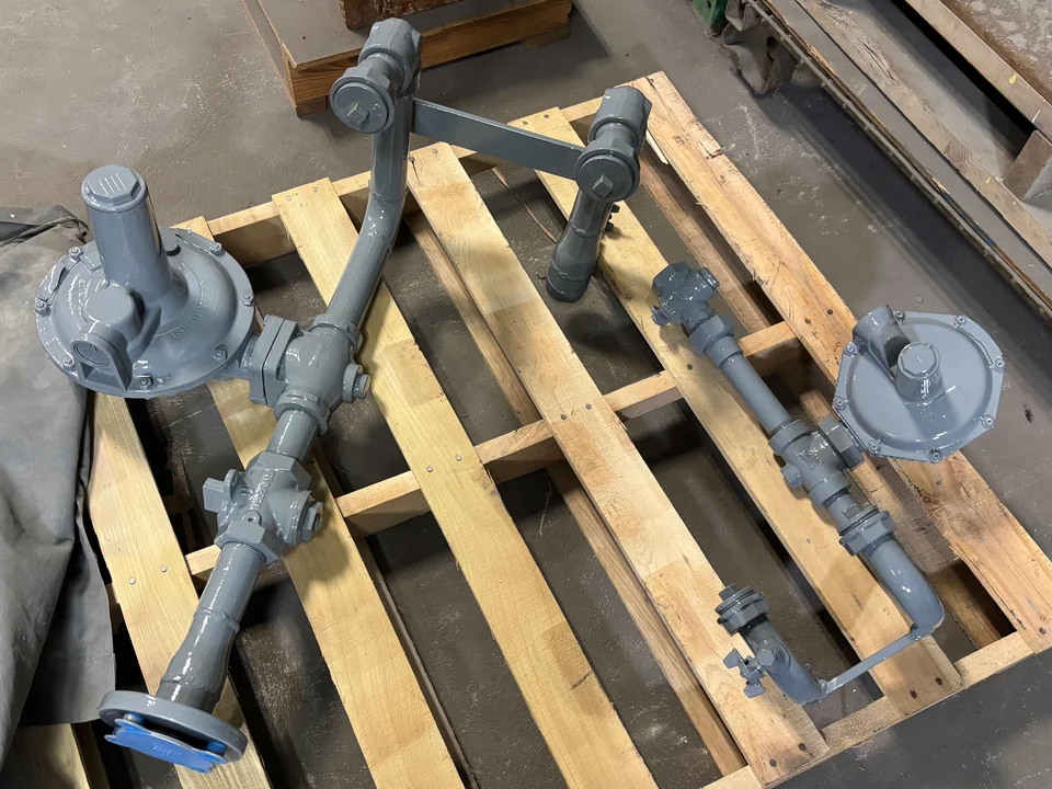 Two residential-style natural gas regulator assemblies with flanged inlets, built for light commercial use.
