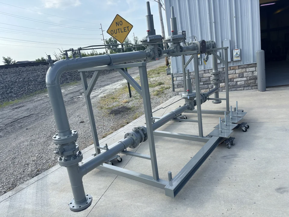 Skid-mounted high-capacity gas regulator run with vent stacks, staged outside the JNL Fab shop.