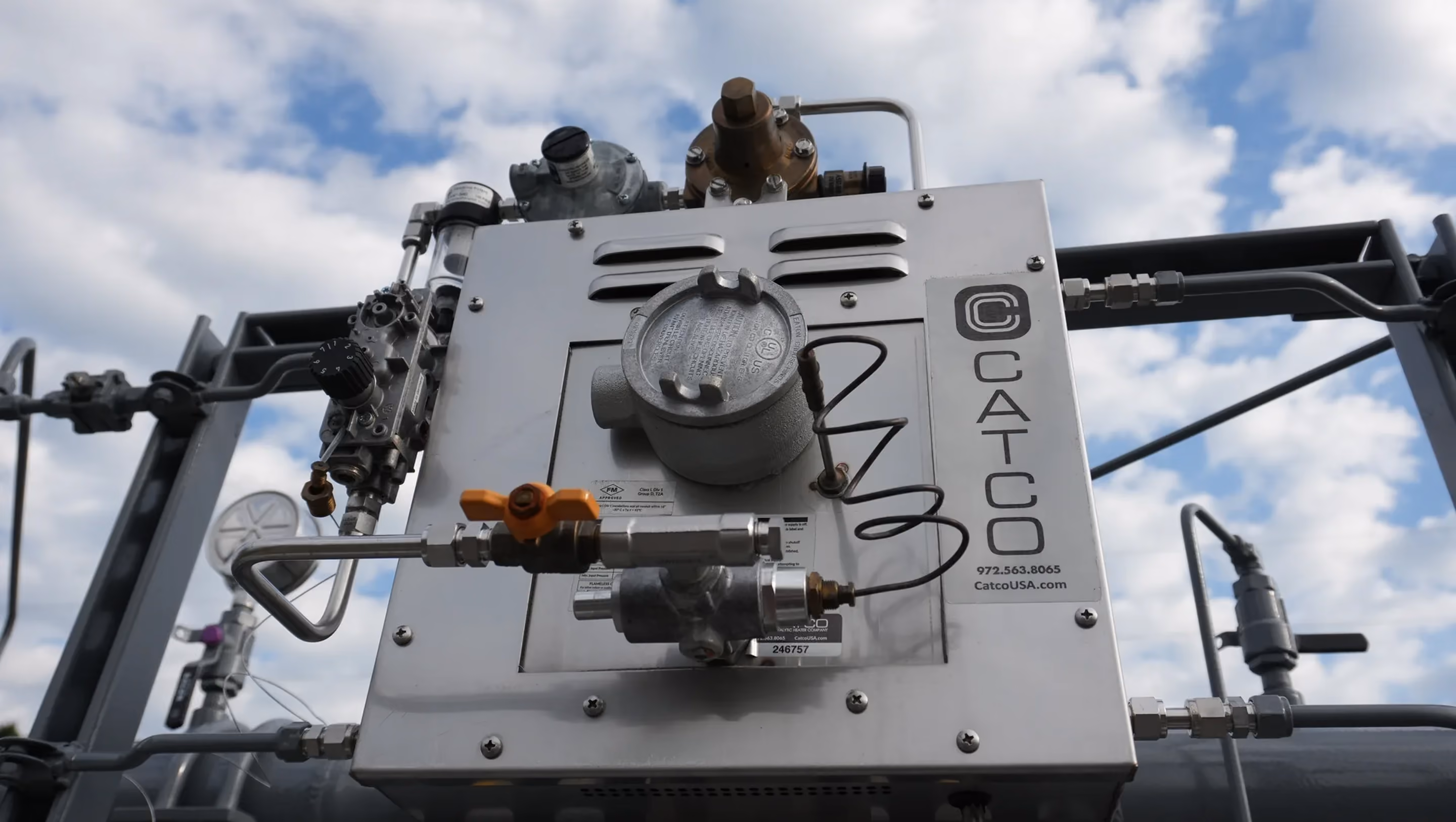 CATCO catalytic heater on a natural gas station skid, seen from below against a blue sky.