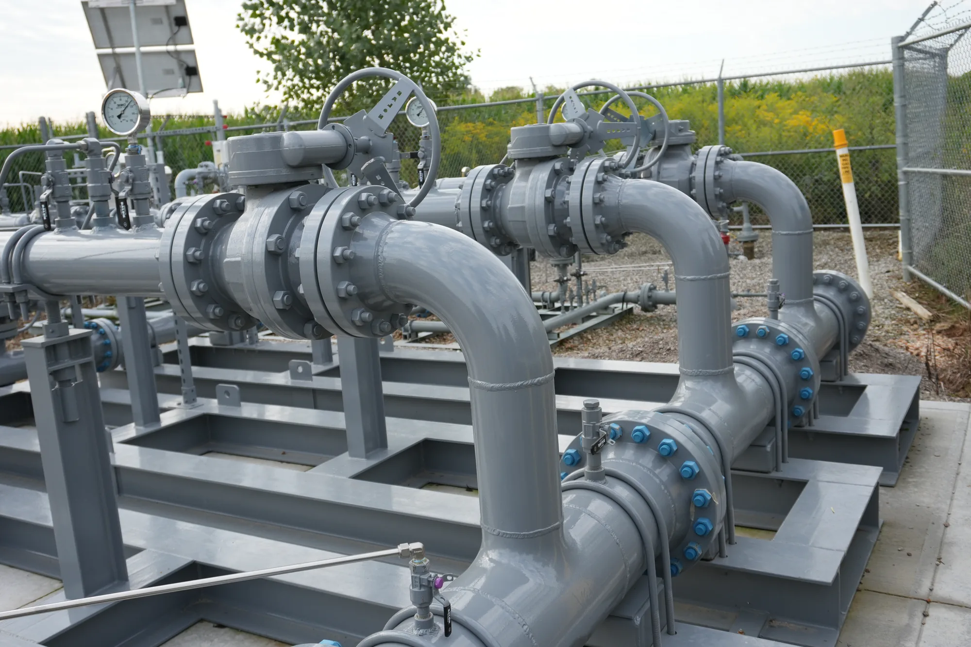 Natural gas regulation skid with twin handwheel valves, bolted flanges and solar-powered telemetry.