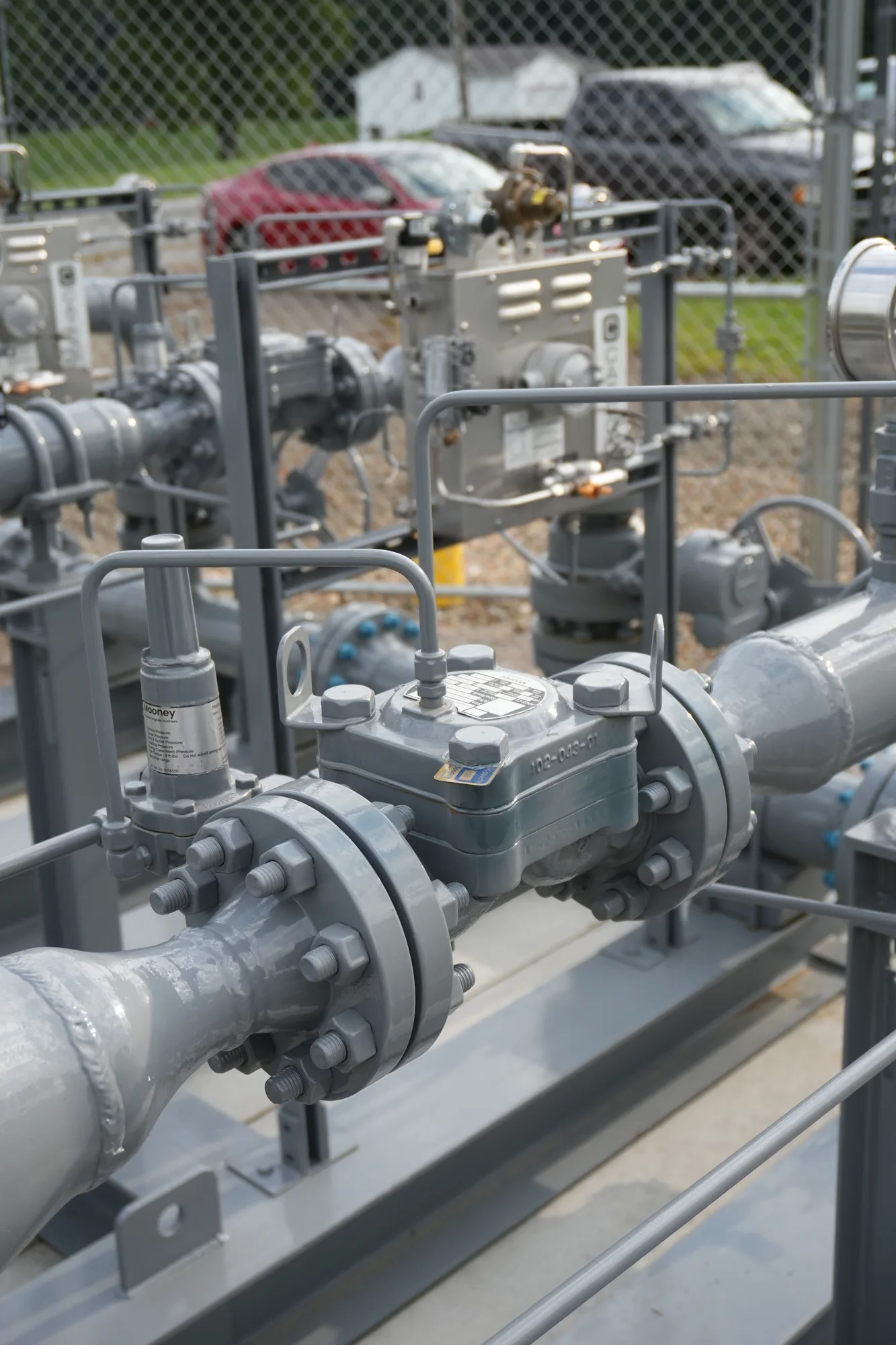 Mooney regulator on bolted flanged piping at a natural gas station, with catalytic heaters behind.