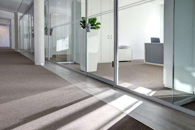 Anodized silver Küberit profile separating carpet from LVT flooring