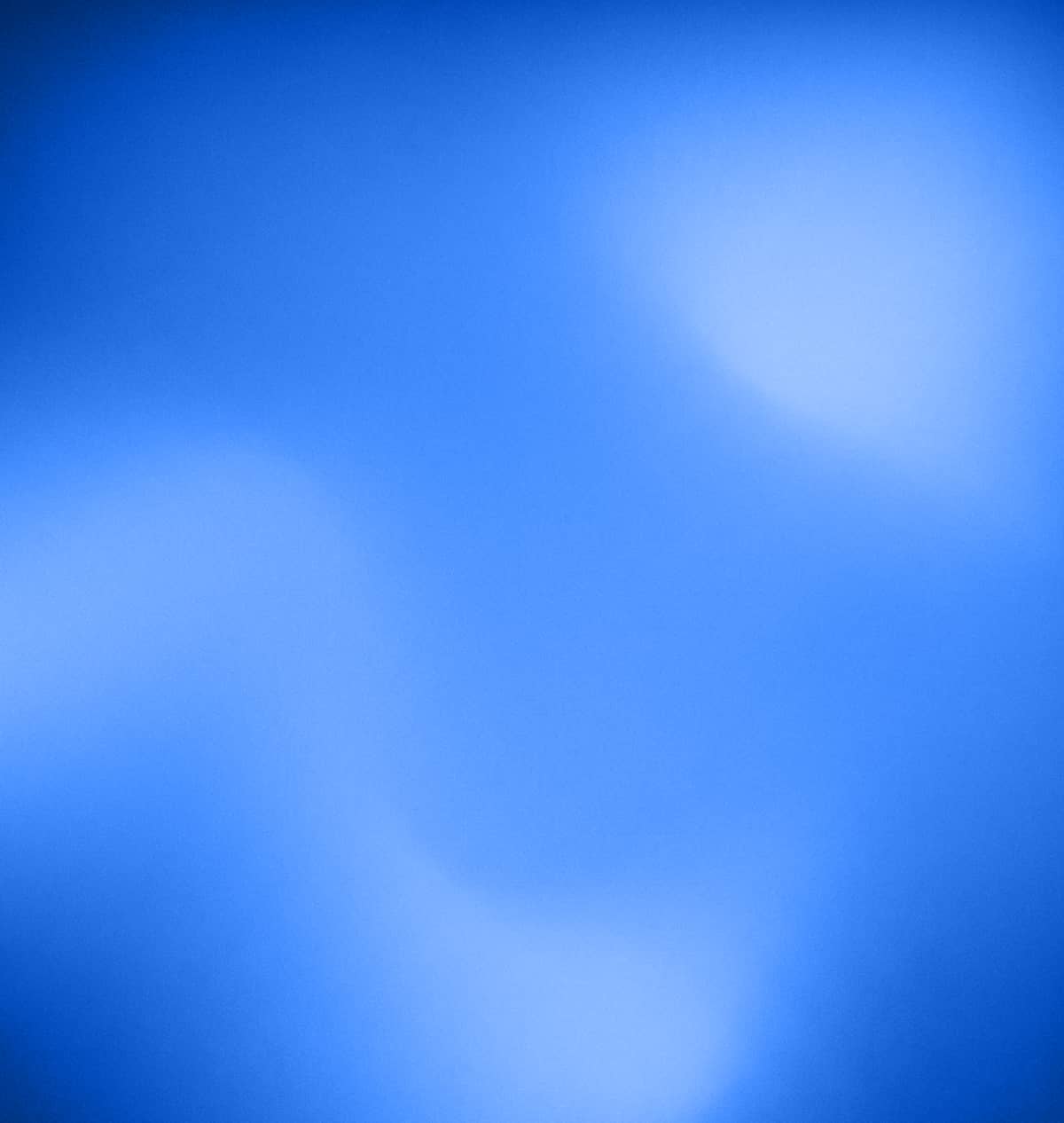 Abstract blurred blue background with soft light spots.