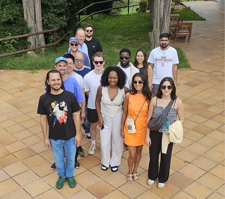 Group of diverse people standing together outdoors on a brick patio.