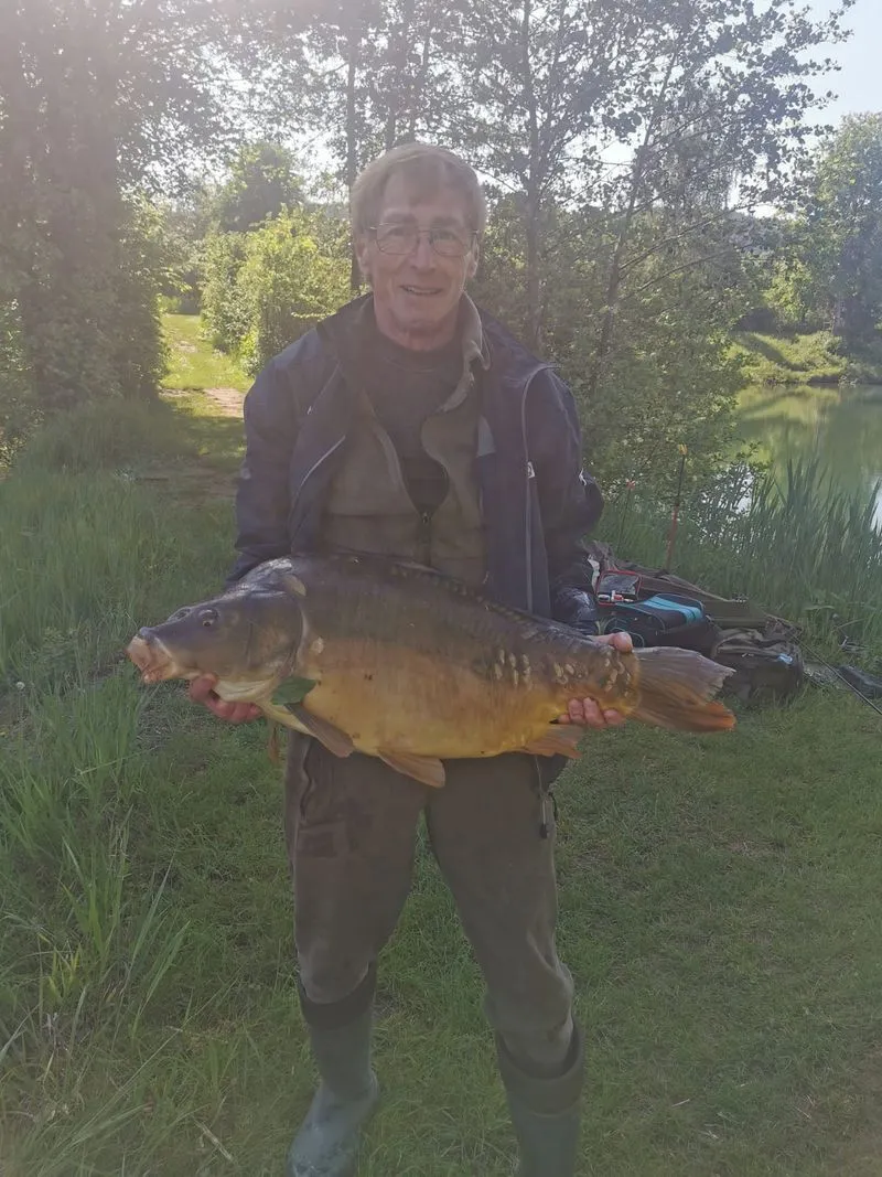 Georg Huber, ehemaliger Inhaber von Angelsport Huber, mit Spiegelkarpfen am See