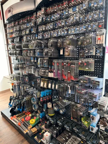 Verkaufstheke mit verschiedenen Verpackungen von Angelzubehör und Zubehörteilen in einem Laden.