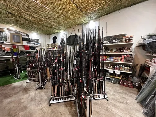 Laden mit Angelruten in Ständern, Regalen mit Angelzubehör und Ausrüstung an den Wänden.