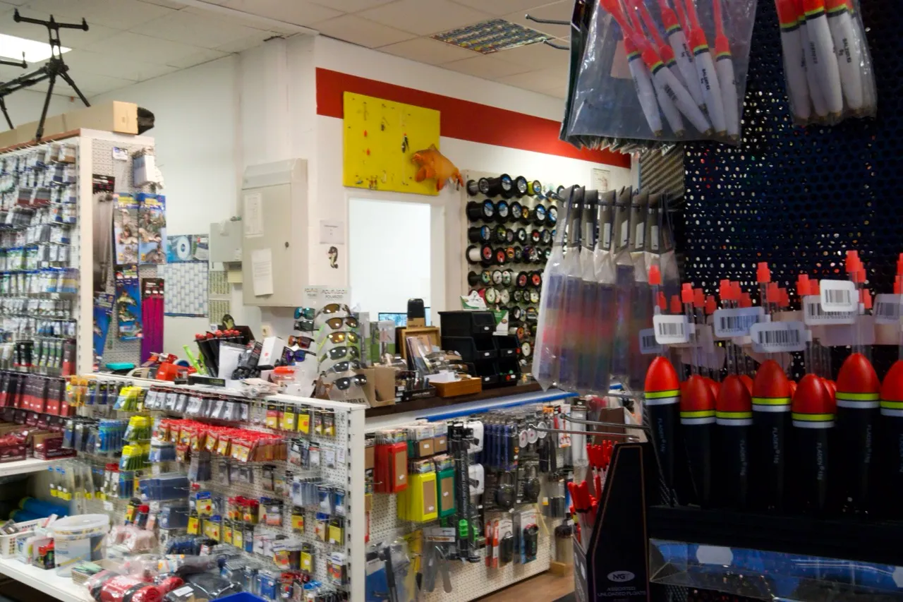 Innenaufnahme eines Angelgeschäfts mit Angelzubehör, Schwimmern und weiteren Ausrüstungsgegenständen.