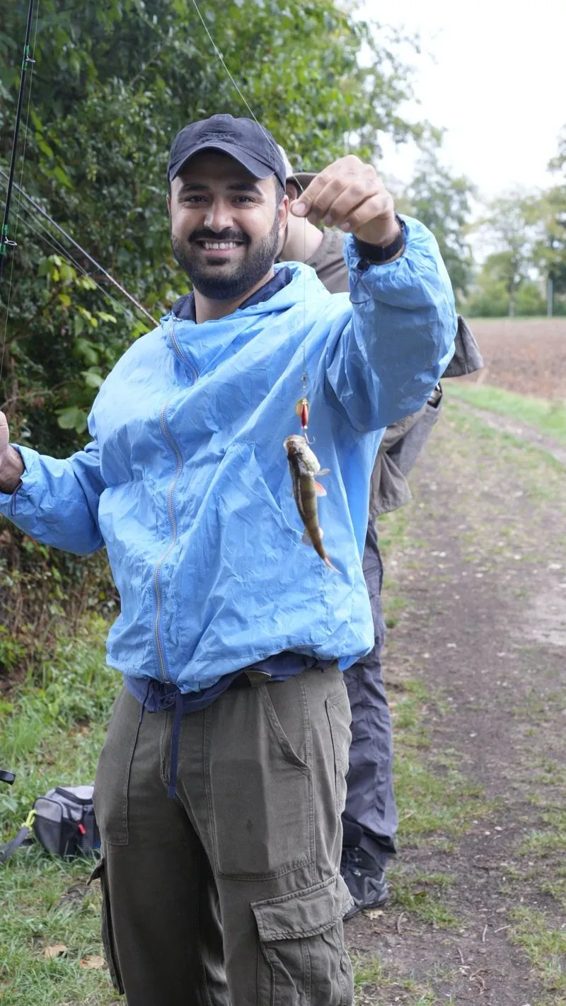 Lachendes Community Mitglied zeigt beim Treffen einen gefangenen Fisch