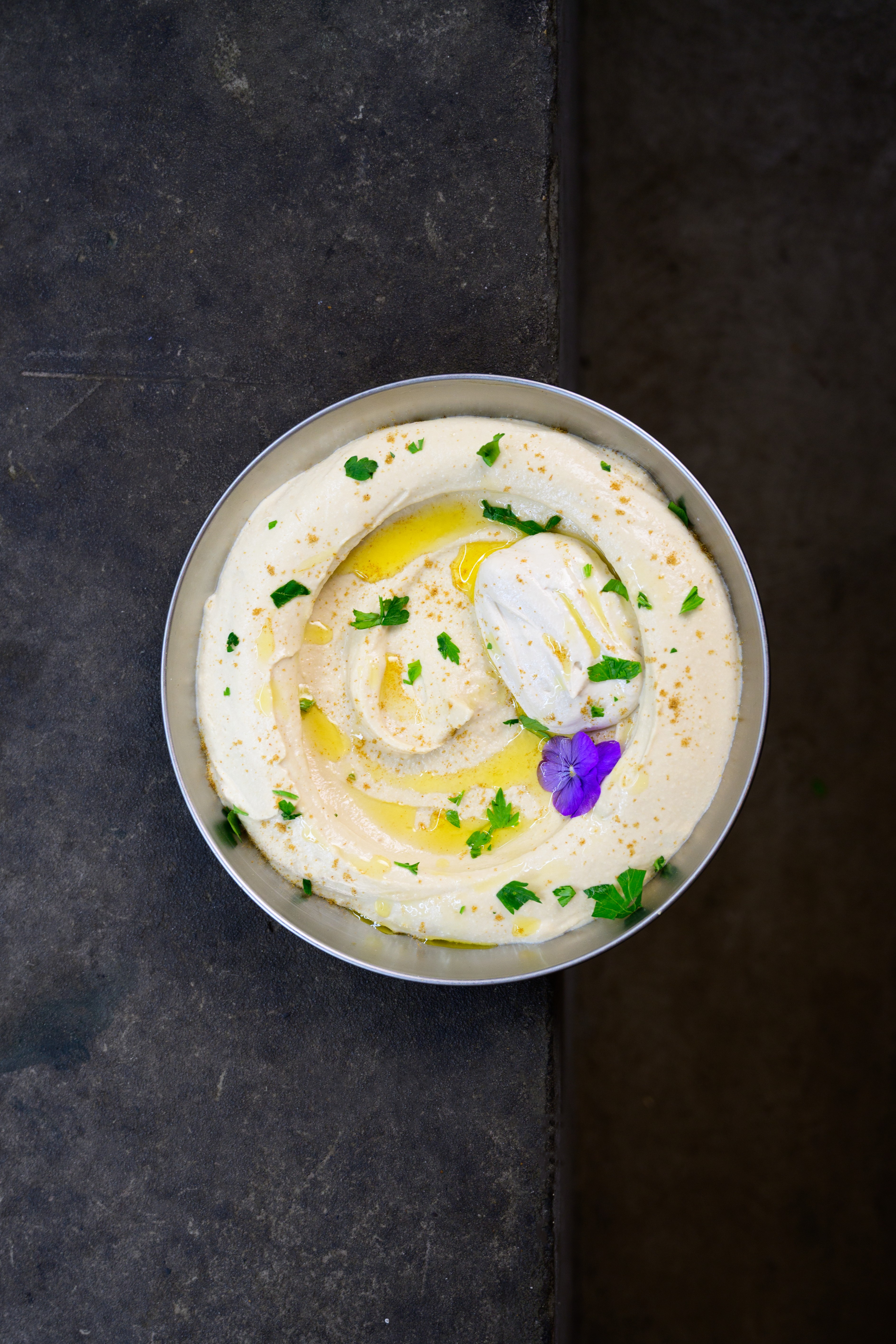 A premium restaurant dish photographed on a dark stone surface