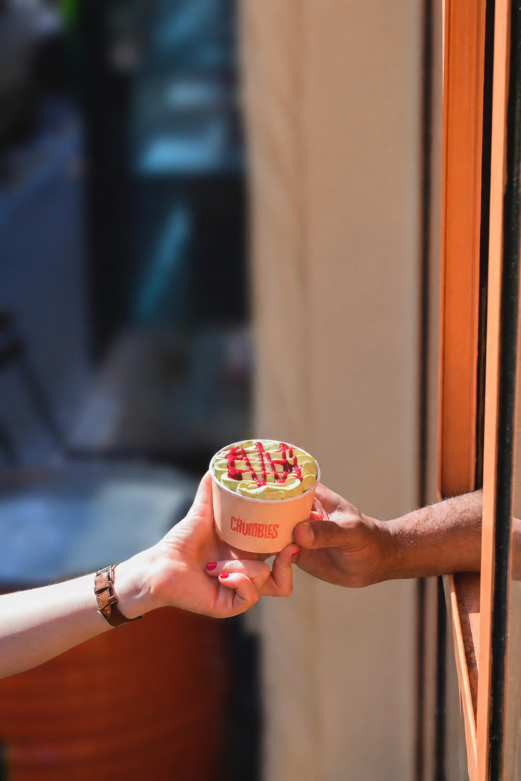 A guest receiving a branded dessert through a restaurant window